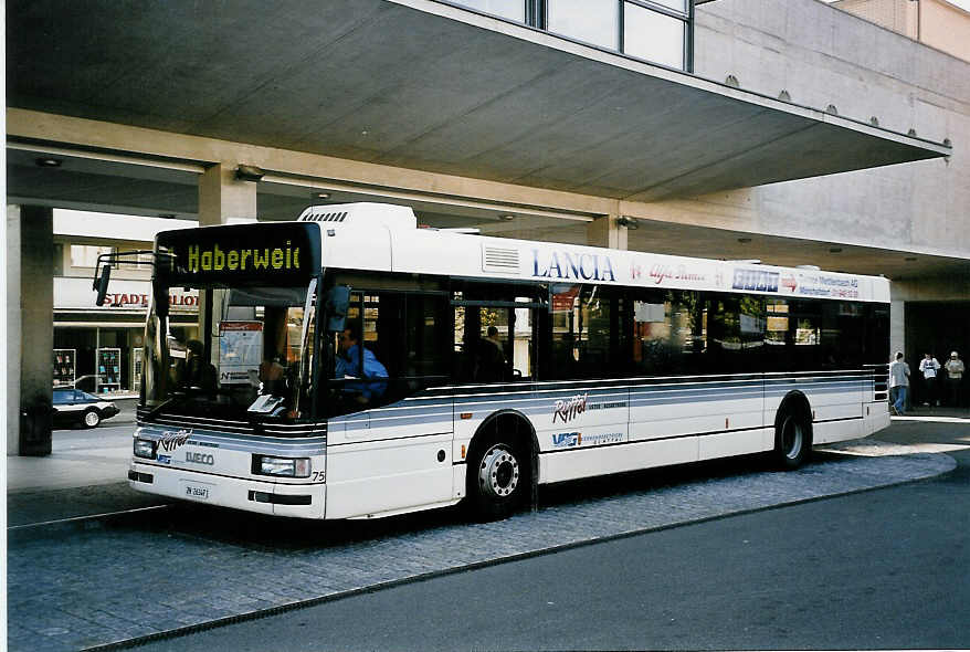 (050'028) - Ryffel, Uster - Nr. 75/ZH 26'347 - Iveco am 6. Oktober 2001 beim Bahnhof Uster