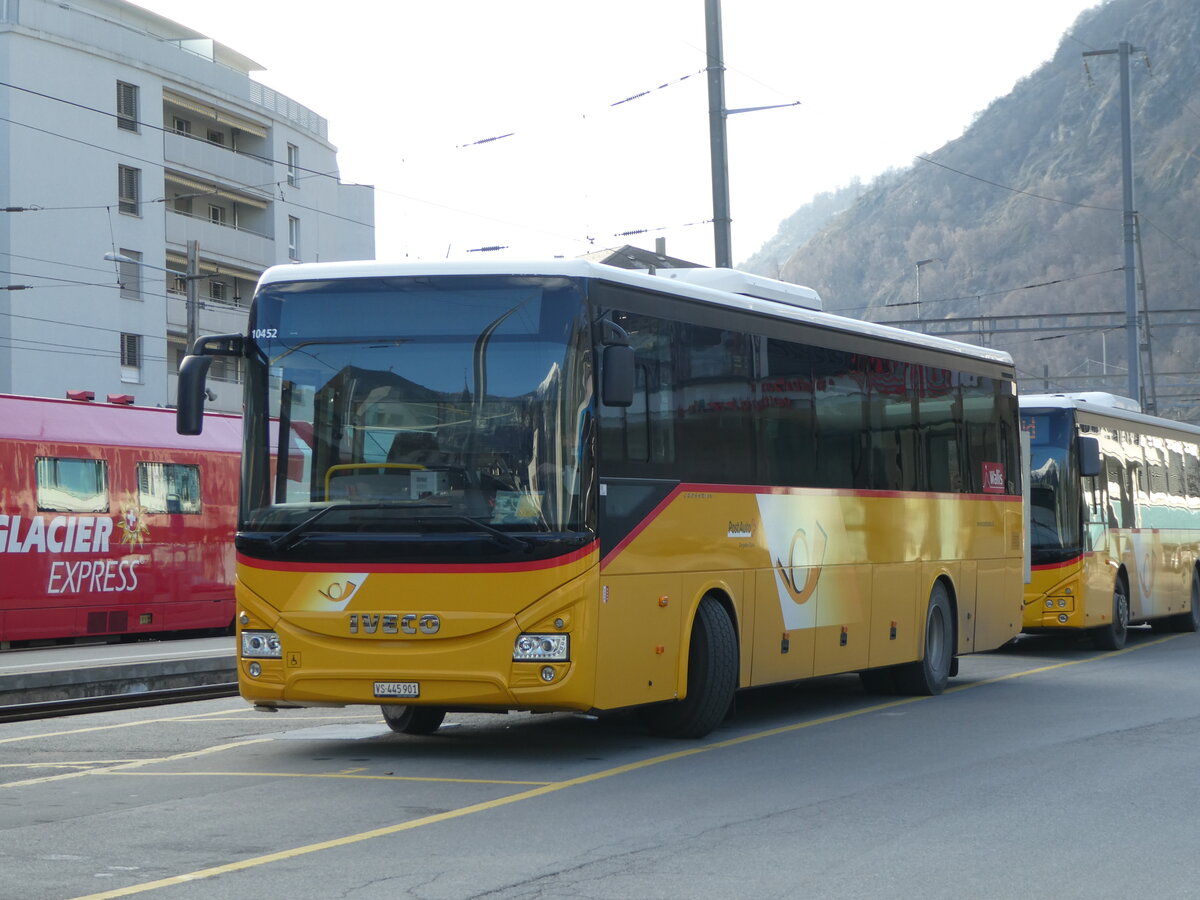 (245'610) - PostAuto Wallis - VS 445'901/PID 10'452 - Iveco am 31. Januar 2023 beim Bahnhof Brig